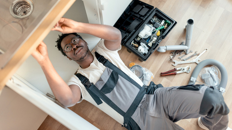 plumber under kitchen sink