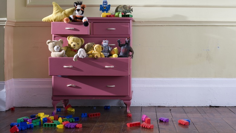 a small kids dresser with toys 