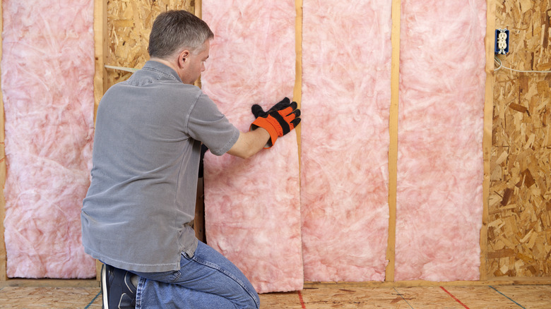 Man adding insulation to attic 