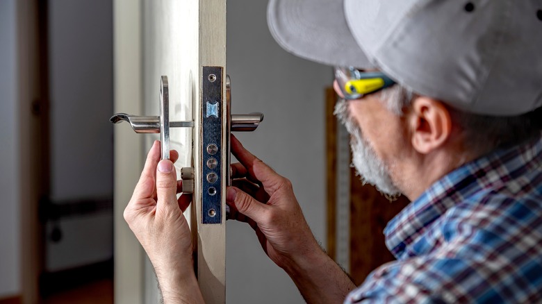 Man installing handle onto an interior door