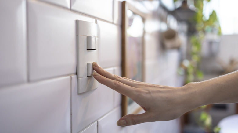 Woman turning on light by switch