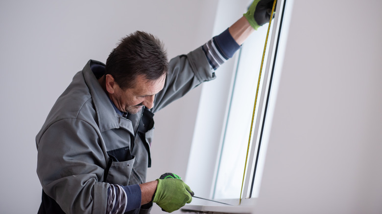 Man measuring window