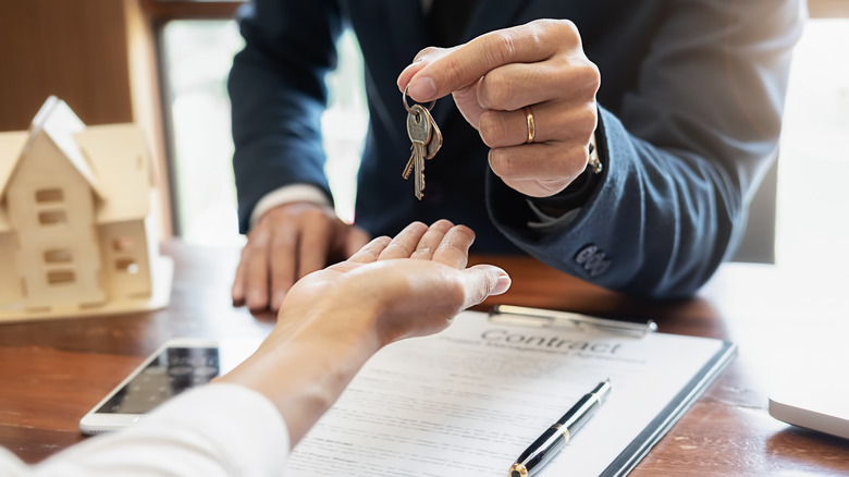 estate agent holding keys above hand