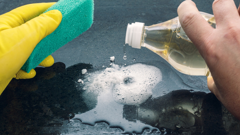 A person pours vinegar to clean a surface