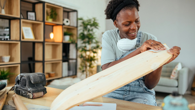 A person is sanding a piece of wood