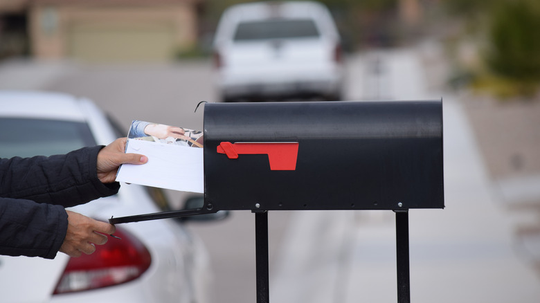 person getting mail from mailbox