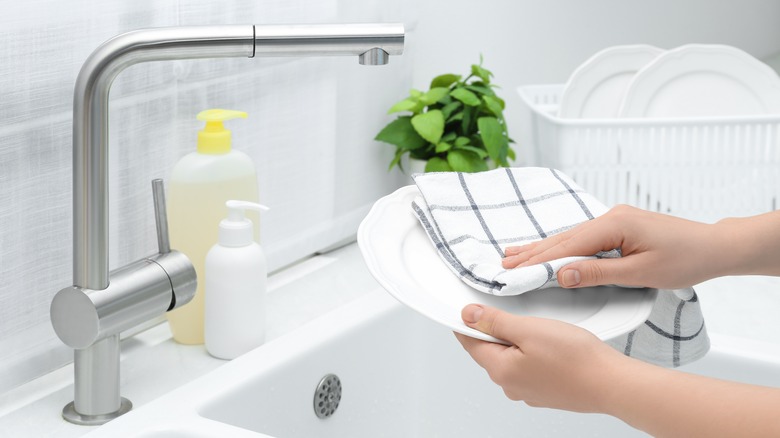 woman drying dishes with cloth