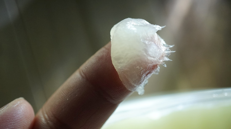 Finger with petroleum jelly on it