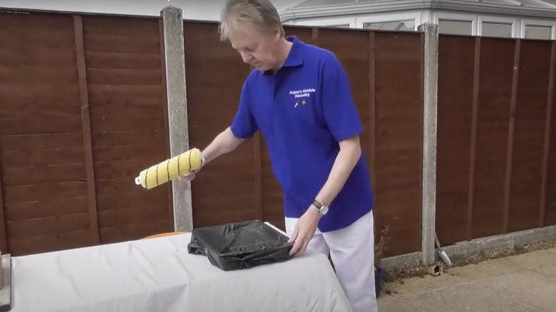 Man with roller tray in a plastic bag