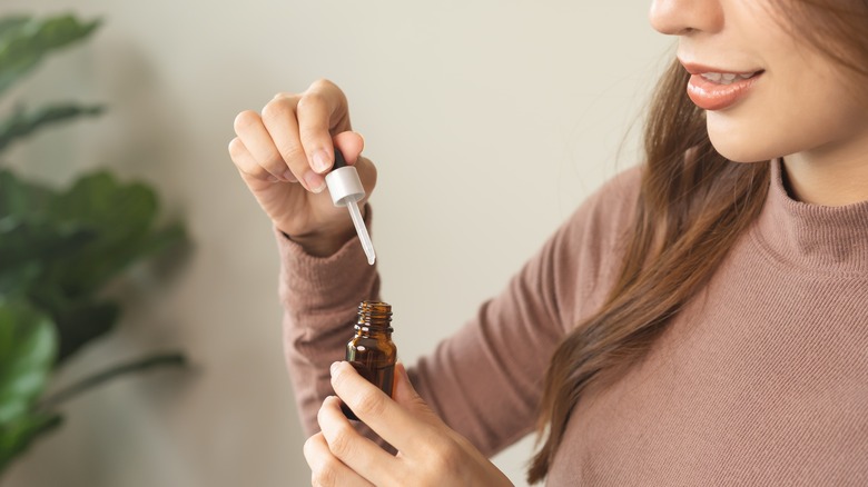 person hold essential oil bottle