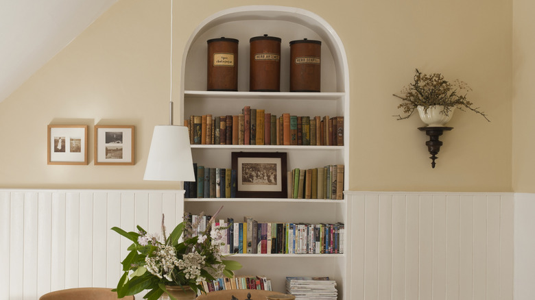 Decorated built-in bookshelf in a kitchen.