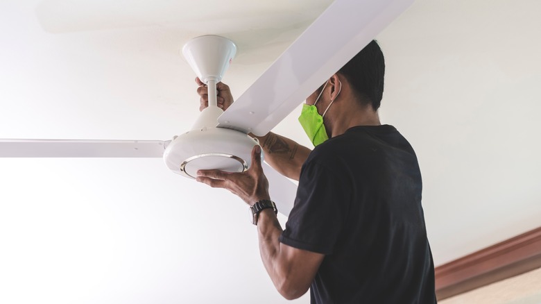 Person working on ceiling fan