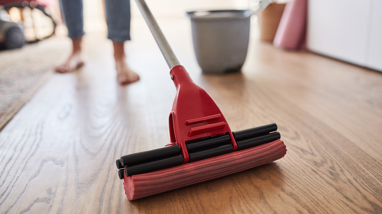 person using floor sponge mop