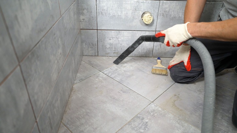 Person vacuuming bathroom floor