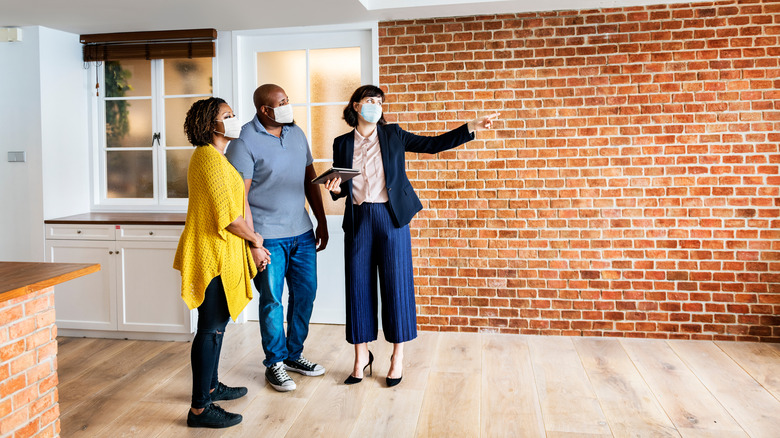 Masked couple looking at house