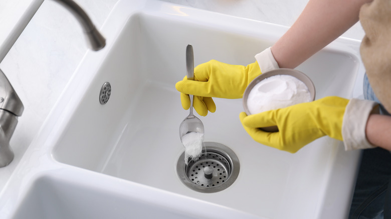 Sprinkling baking soda in sink