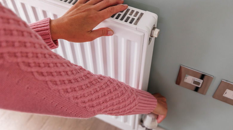 person adjusting radiator