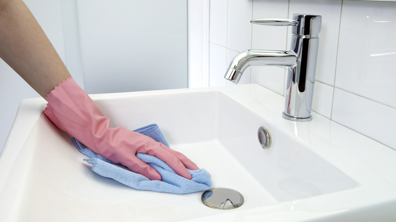Cleaning bathroom sink with microfiber cloth