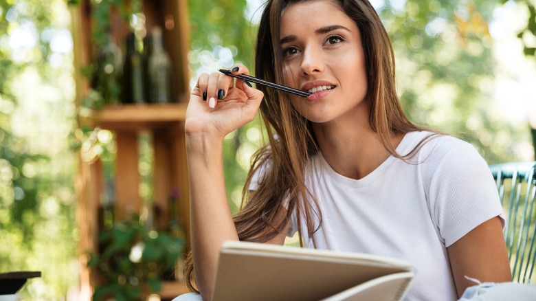 Woman thinking writing in backyard