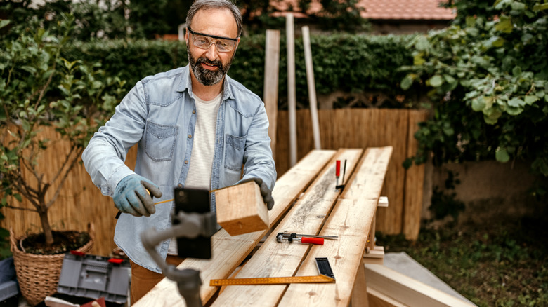 Man cutting wood in backyard