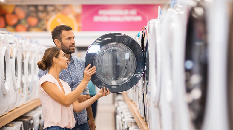 Man and woman shopping for a washing machine