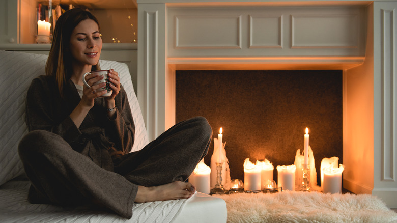 woman relaxing near lit candles