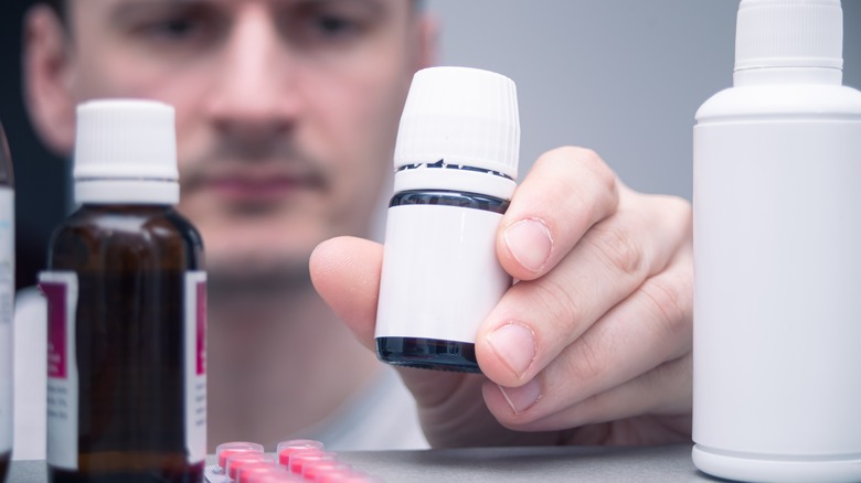 Man putting bottle in cabinet