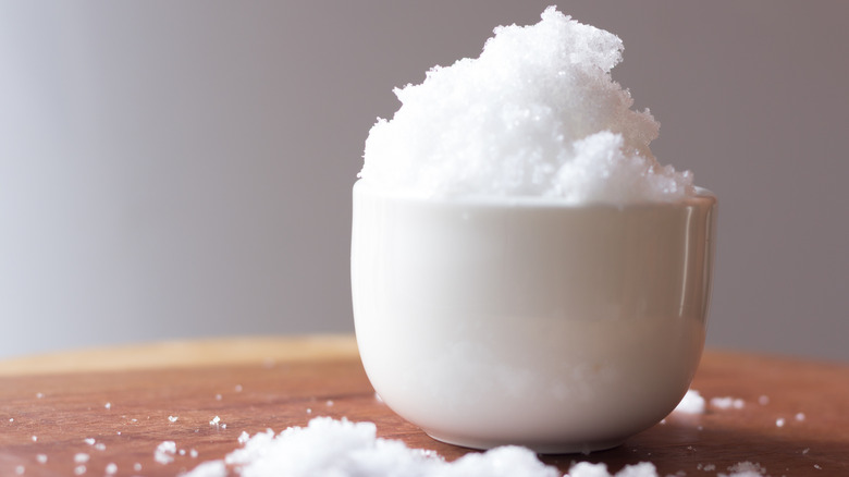 A white bowl with Epsom salt sits on a table