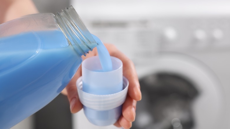 Person pouring detergent