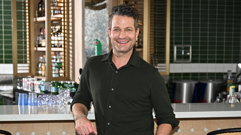 Nate Berkus smiling while standing by a bar.