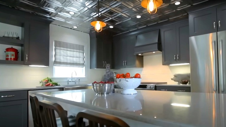 Kitchen with tin tile ceiling and dark gray cabinets.