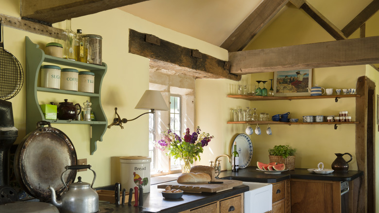 Rustic kitchen with exposed wood features and yellow walls.