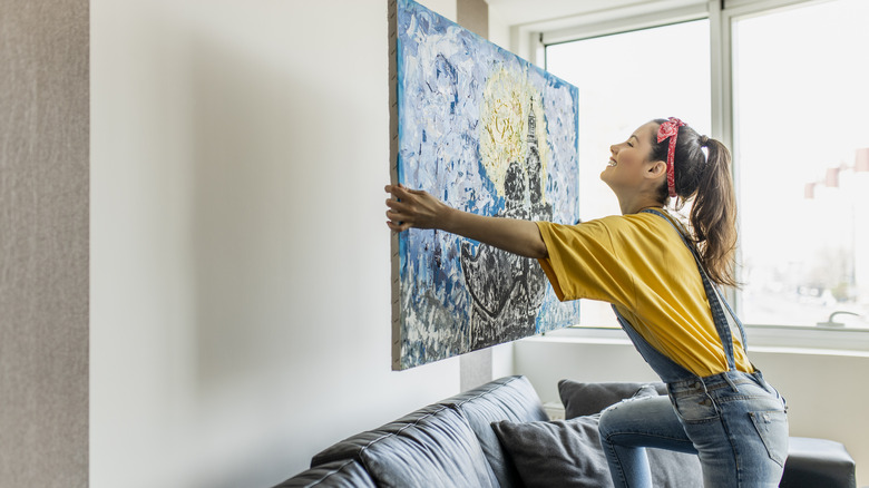 Woman hanging artwork