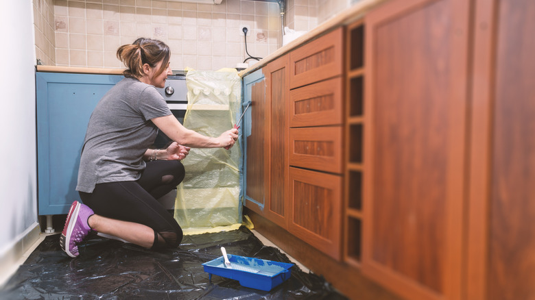 Woman painting kitchen cabinets