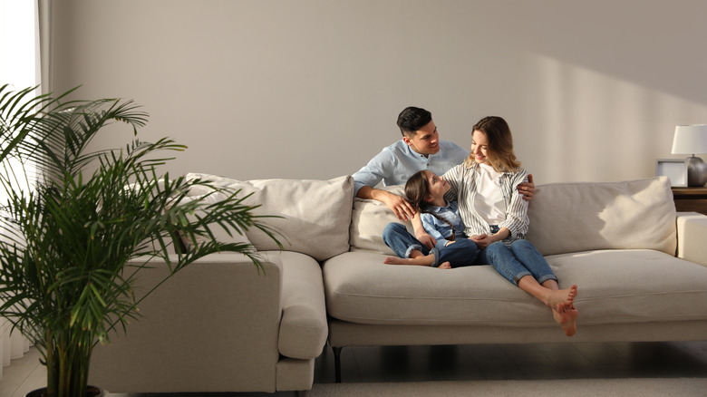 Family sitting on couch happily