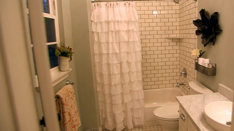 Small bathroom with white fixtures and decor