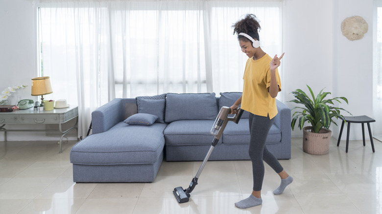 Woman vacuuming and playing music