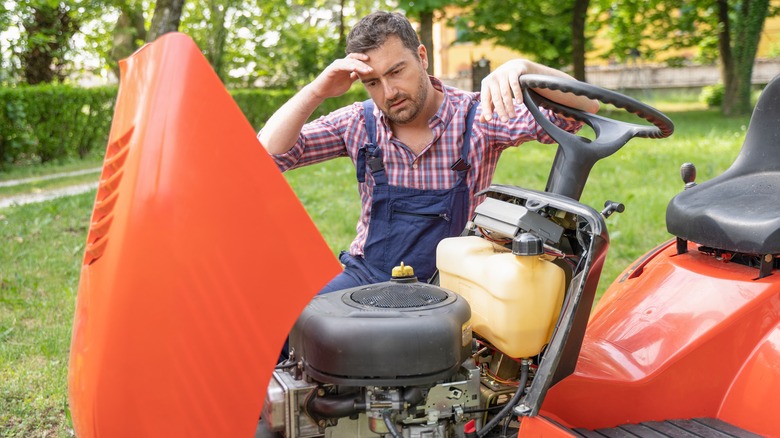 Man puzzling over stalled mower