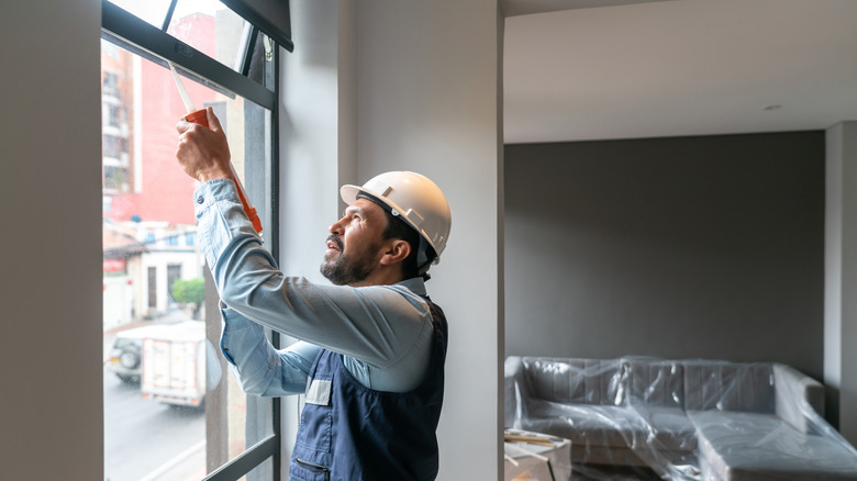 Person using caulk on a window