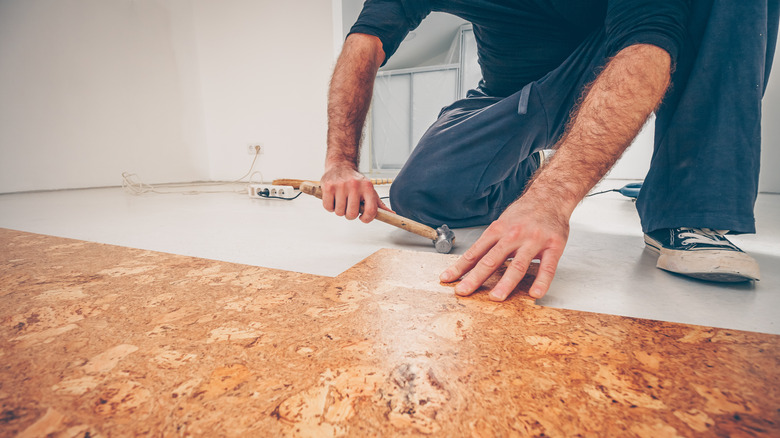 man hammering cork flooring