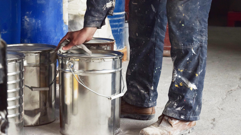 Man wiping paint can lid 