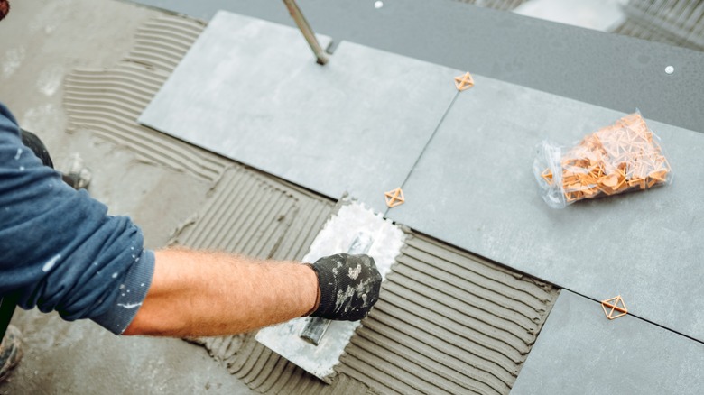 Contractor installs floor tiles