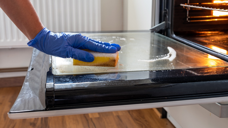 Hand shown scrubbing oven door