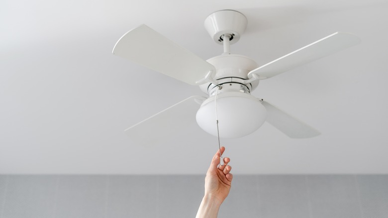 Hand pulling ceiling fan cord