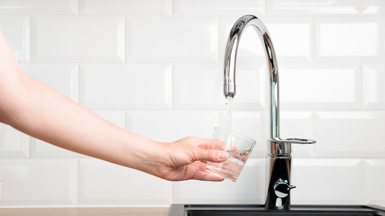 Someone filling up a glass of water