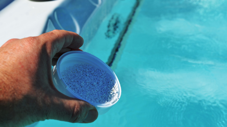 adding chlorine granules to hot tub