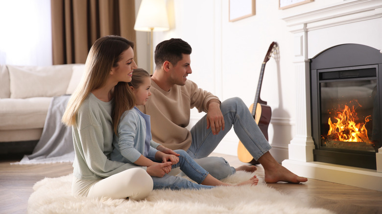 Family warming by a fireplace