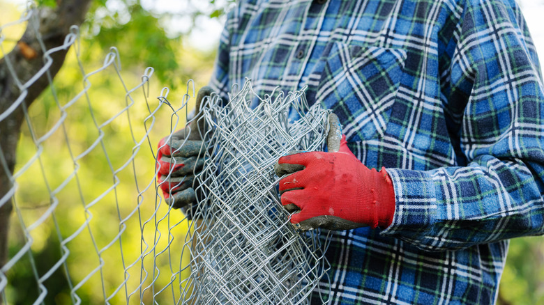 Person holding chain link mesh