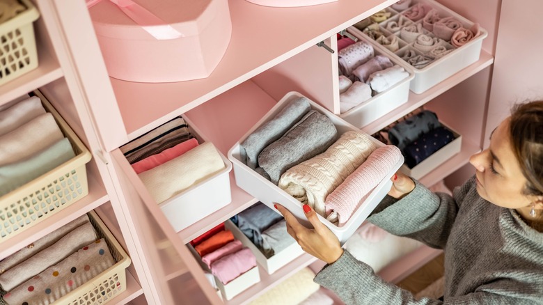 Woman organizing clothing in closet