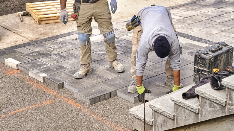 Workers laying interlocks patio